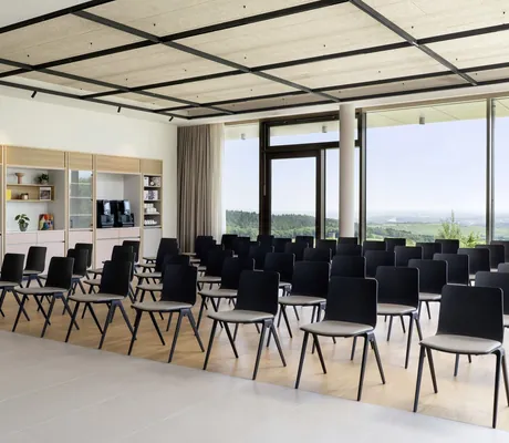 Reihenbestuhlung im Tagungsraum des WALD.WEIT mit Holzdecke und Panoramafenster