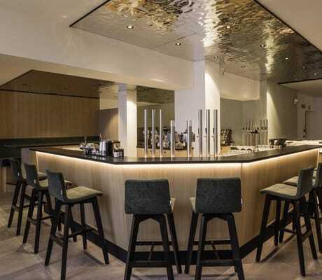 Blick auf die Hotelbar des MyParadies in Sulden, Stühle um die Bar