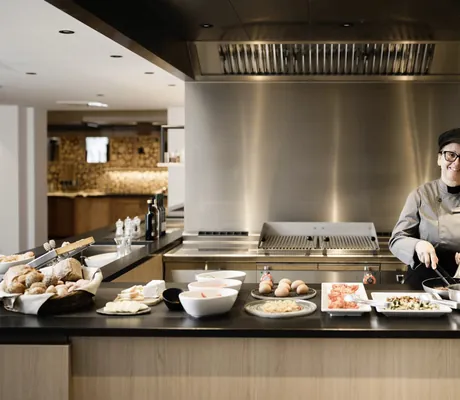 Eine Köchin lächelt im Restaurant des MyParadies, während sie kocht.