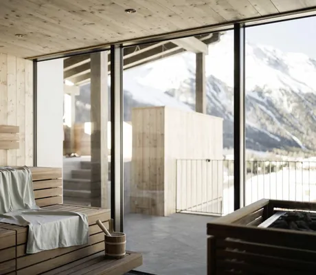 Blick von der Panoramasauna auf die schneebedeckten Berge.