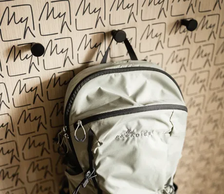 Ein Tagesrucksack des MyParadies in Sulden hängt in einer Garderobe mit Hotellogo