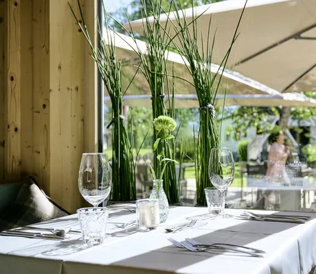 Ein eingedeckter Tisch mit Blick nach draußen im Aktivhotel Sonnenburg in Riezlern.