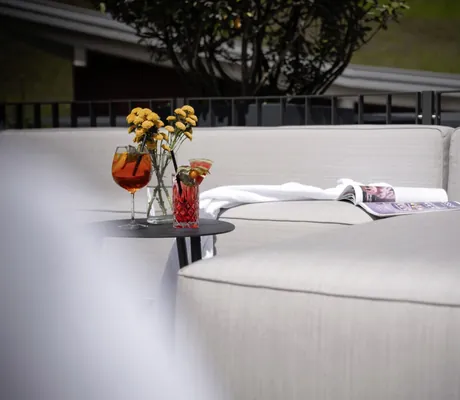 Blick auf den Außen-Relaxbereich mit Aperitif und Blumenstrauß.
