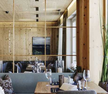 Blick in den gemütlichen Restaurantbereich des Hotel Sonnenburg mit Naturmaterialien.