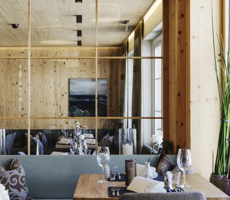 Blick in den gemütlichen Restaurantbereich des Hotel Sonnenburg mit Naturmaterialien.