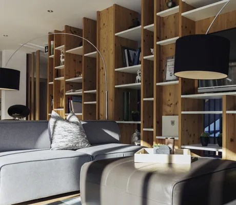 Blick in einen Relaxraum des Hotels Sonnenburg mit Fernseher, Couch und Büchern.