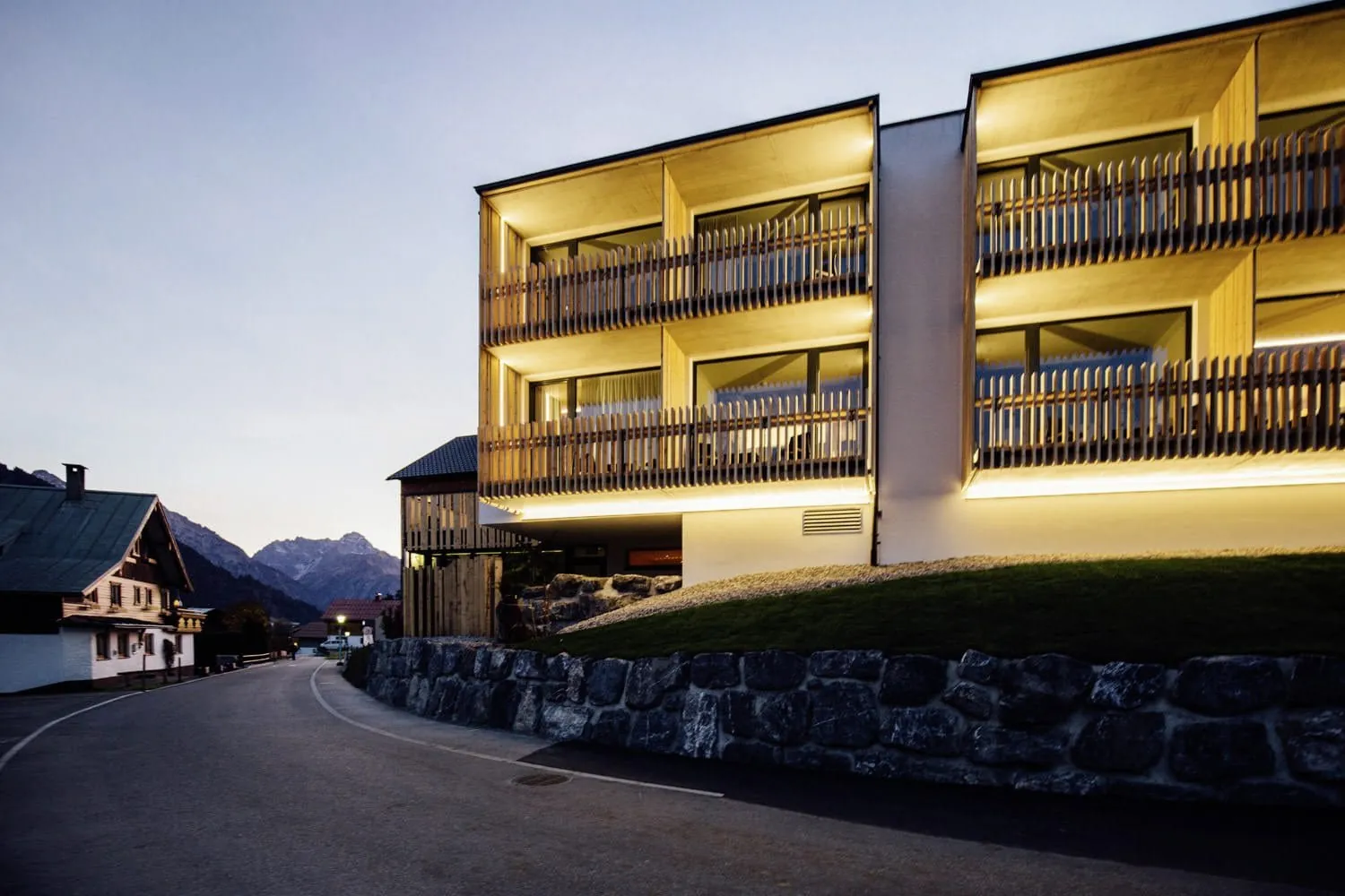 Beleuchtete Außenansicht des Hotel Sonnenburg in Rietzlern mit Holz-Balkonen.