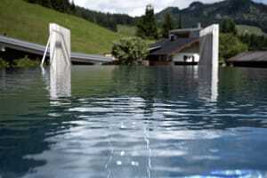 Blick vom Infinitypool des Hotel Sonnenburg mit Aussicht auf grüne Täler und Hügel.