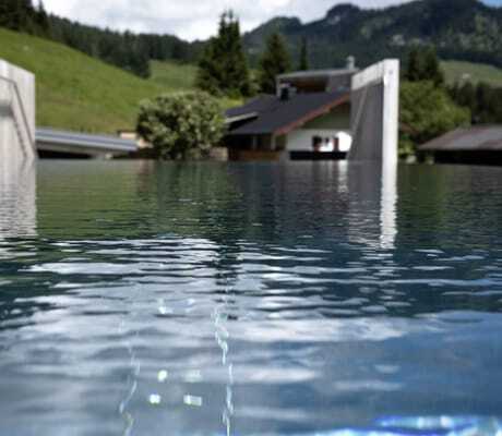 Blick vom Infinitypool des Hotel Sonnenburg mit Aussicht auf grüne Täler und Hügel.
