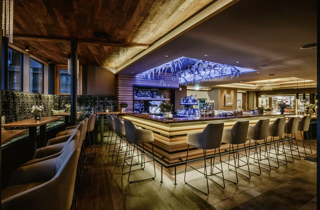 Hansi Bar im Bergkristall - Mein Resort im Allgäu mit Geweihen an der Decke und blauem Licht