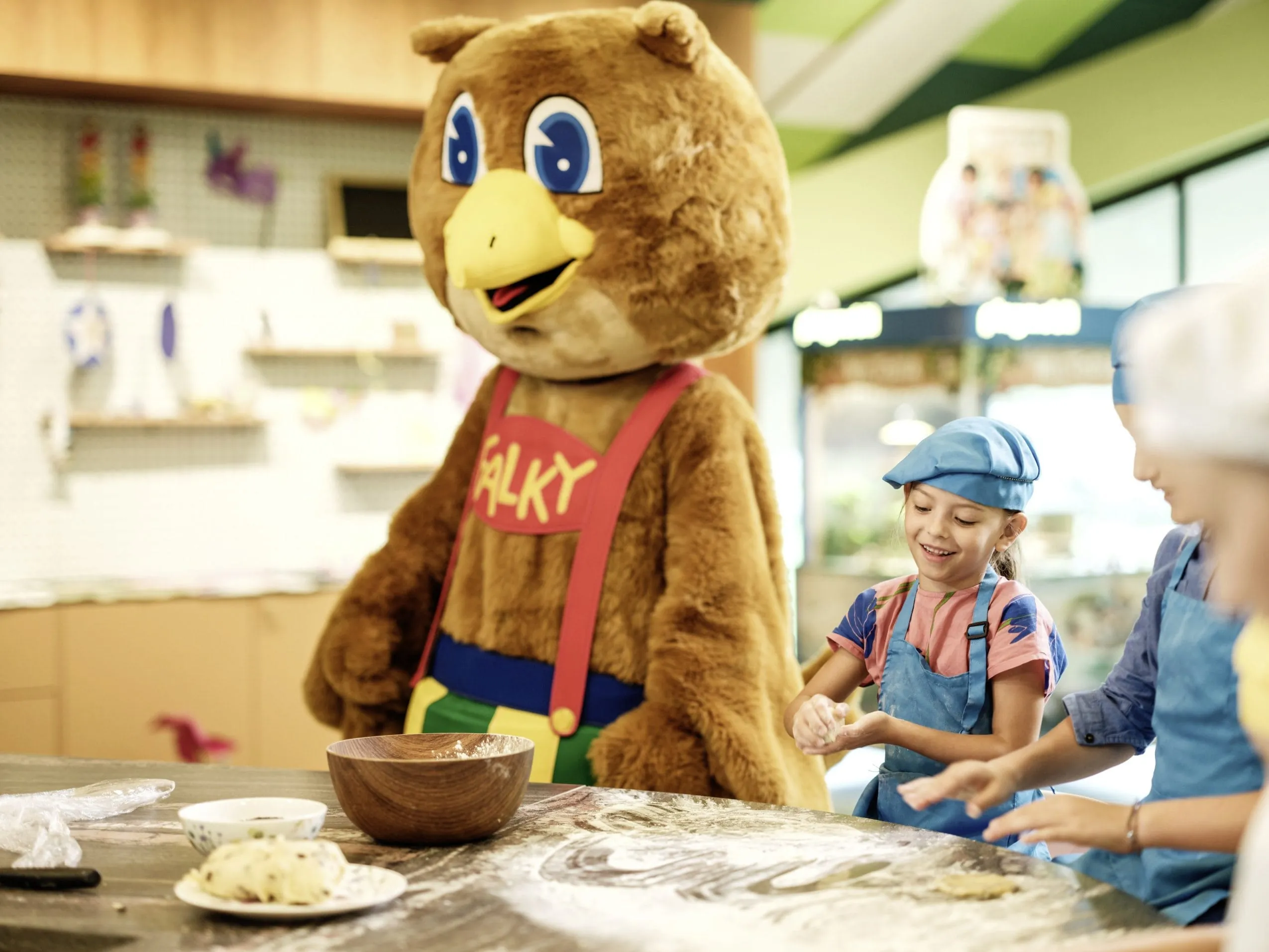 Kinder beim Backkurs im Falkensteiner Family Hotel Montafon mit Maskottchen Falky in der Küche