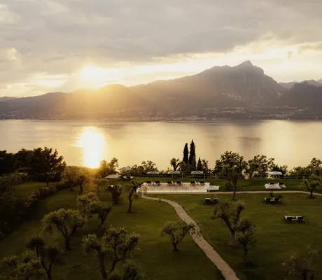 großer Garten im Cape of Senses mit Olivenbäumen und Daybeds oberhalb des Gardasees