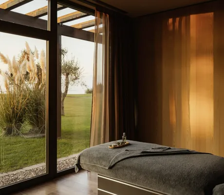 Massageliege mit grauem Frotteebezug im Behandlungsraum des Cape of Senses