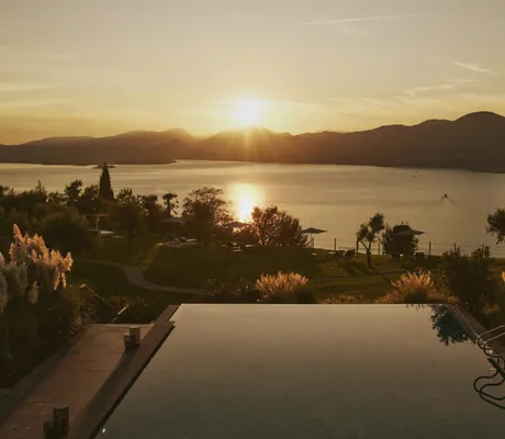 Outdoorpool im Cape of Senses im Abendrot mit Blick auf den Gardasee