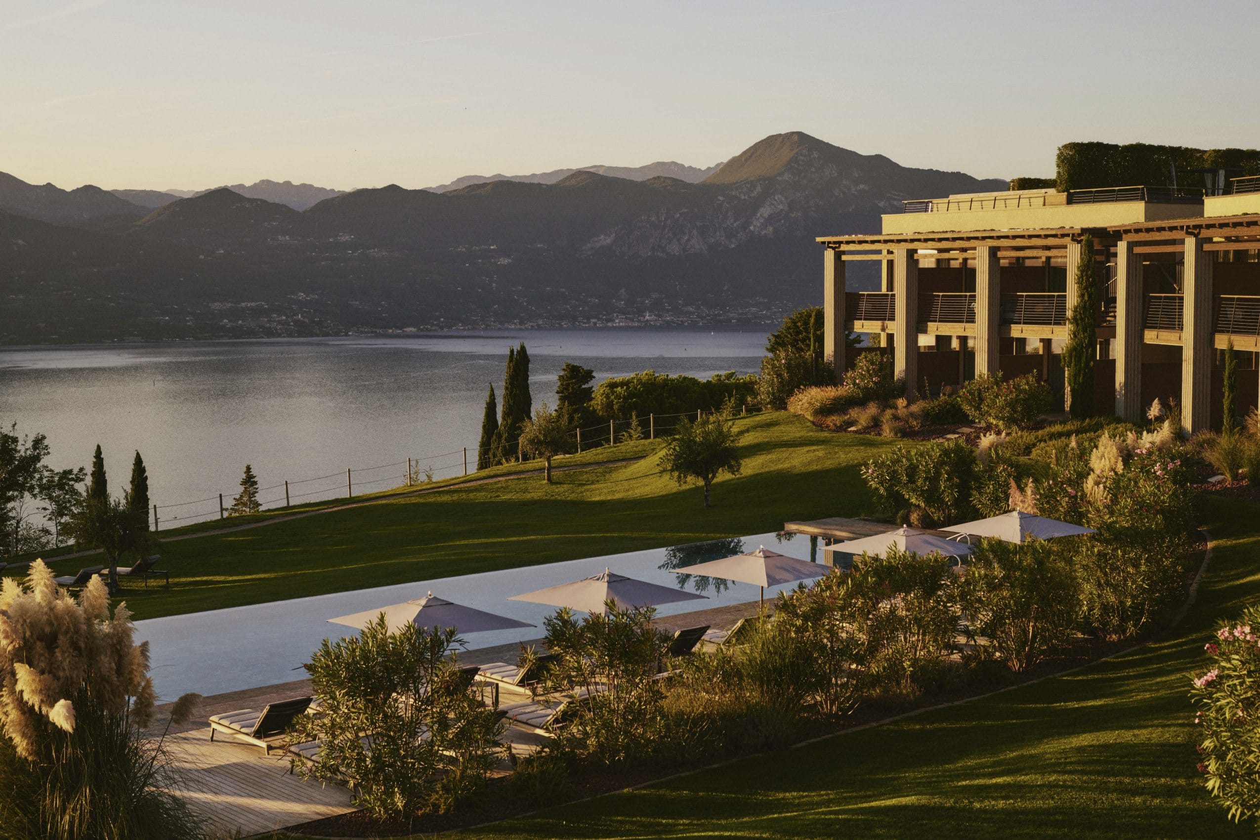 Fassade des Cape of Senses im Sonnenaufgang mit Blick auf den Outdoorpool und den Gardasee