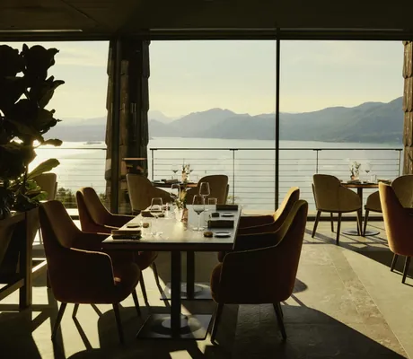 eingedeckte Tische mit gelben Sesseln im Cape of Senses mit Blick auf den Gardasee