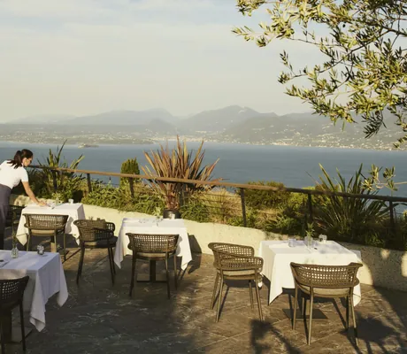 Frau deckt Tisch auf der Terrasse des Cape of Senses oberhalb des Gardasees