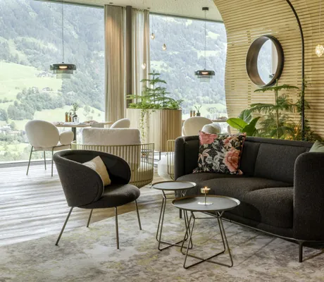 Bar-/Restaurantbereich mit Holzwänden und dunklen und hellen Polstermöbeln im DAS.GOLDBERG
