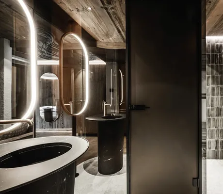 Badezimmer im Wellnesshotel Der Engel mit italienischen grünen Fliesen und runden Waschbecken