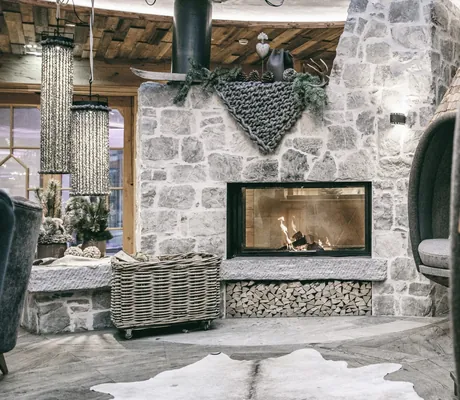 Schindelholzkojen am offenen Kamin in der Lobby des Wellnesshotel Der Engel