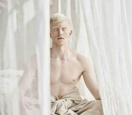 blonder Mann sitzt mit geschlossenen Augen im Kuschelnest des Wellnesshotel Der Engel