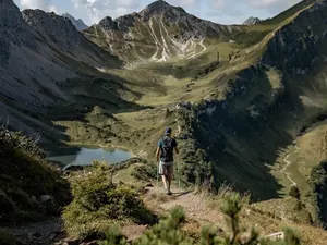 Mann mit kurzer Hose wandert mit Wanderstöcken durchs Tannheimer Tal an der Schochenspitze