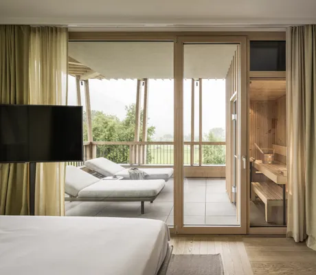 Suite des Falkensteiner Hotel Kronplatz mit privater Sauna und Liegen auf dem Balkon