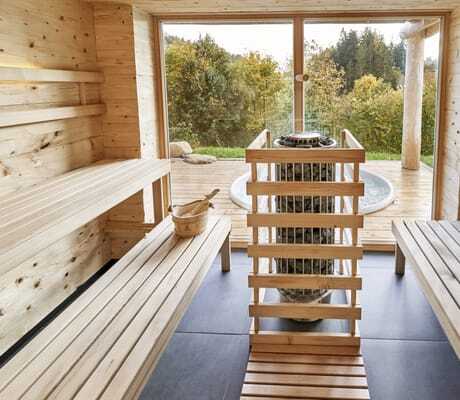 Sauna in den Jakob Chalets mit großen Fenstern und direktem Blick auf die Terrasse mit Whirlpool