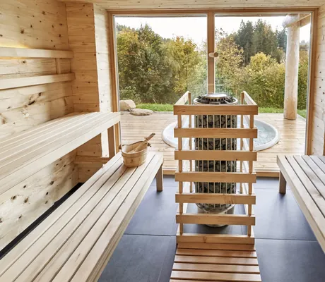 Sauna in den Jakob Chalets mit großen Fenstern und direktem Blick auf die Terrasse mit Whirlpool