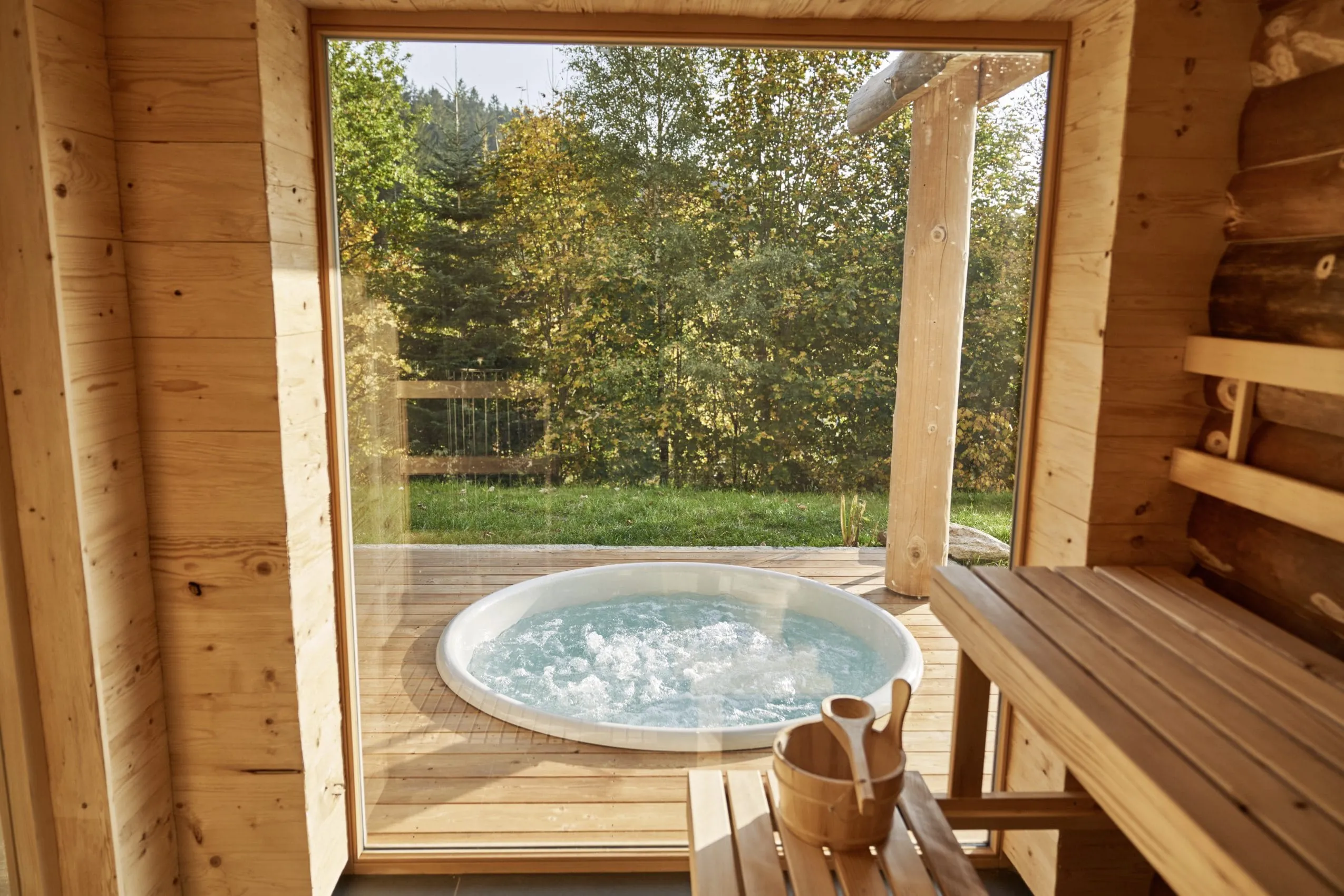 Blick von der Sauna der Jakob Chalets auf den Outdoor-Whirlpool