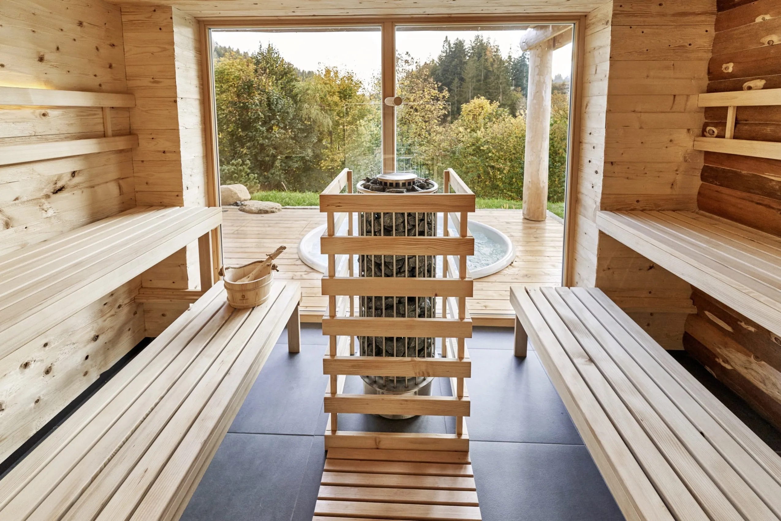 Sauna in den Jakob Chalets mit großen Fenstern und direktem Blick auf die Terrasse mit Whirlpool
