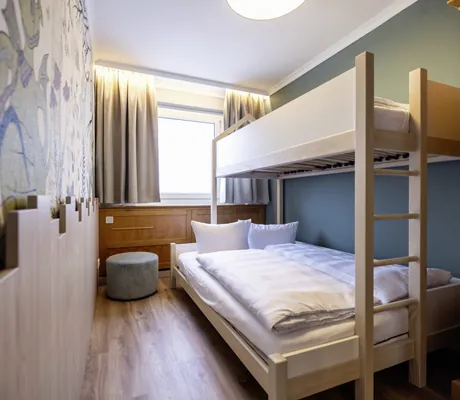 Stockbett aus Holz und Sitzhocker im Kinderzimmer der Superior Plus Suite des Familotel Elldus Resort