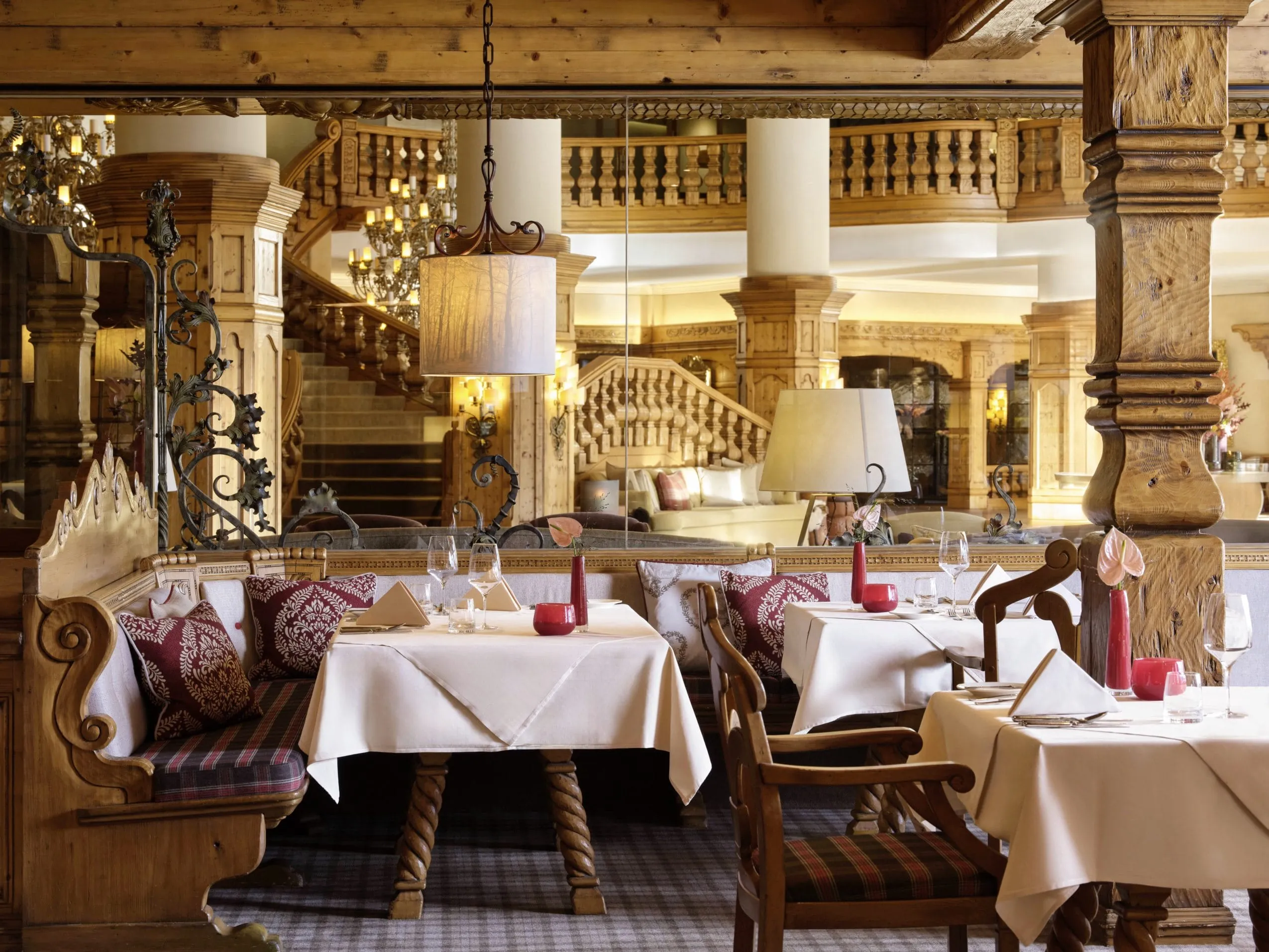 Elegantes Restaurant des Interalpen-Hotel Tyrol mit rustikalen Holzmöbeln, gedeckten Tischen und dekorativen Lampen