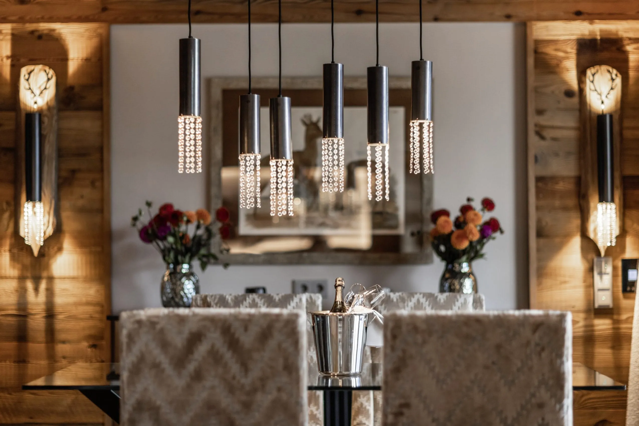 Wohnraum der Suite im Alpin Resort Sacher Seefeld Tirol mit Holzelementen und Designer-Deckenleuchte.