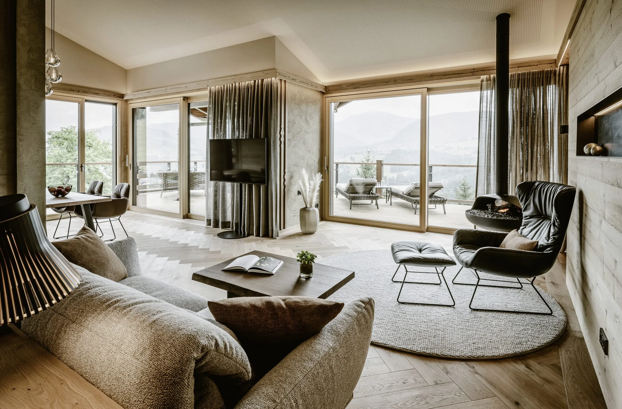 Blick in die Suite des Bergkristall in Oberstaufen mit Sofa, Sessel und Terrasse.