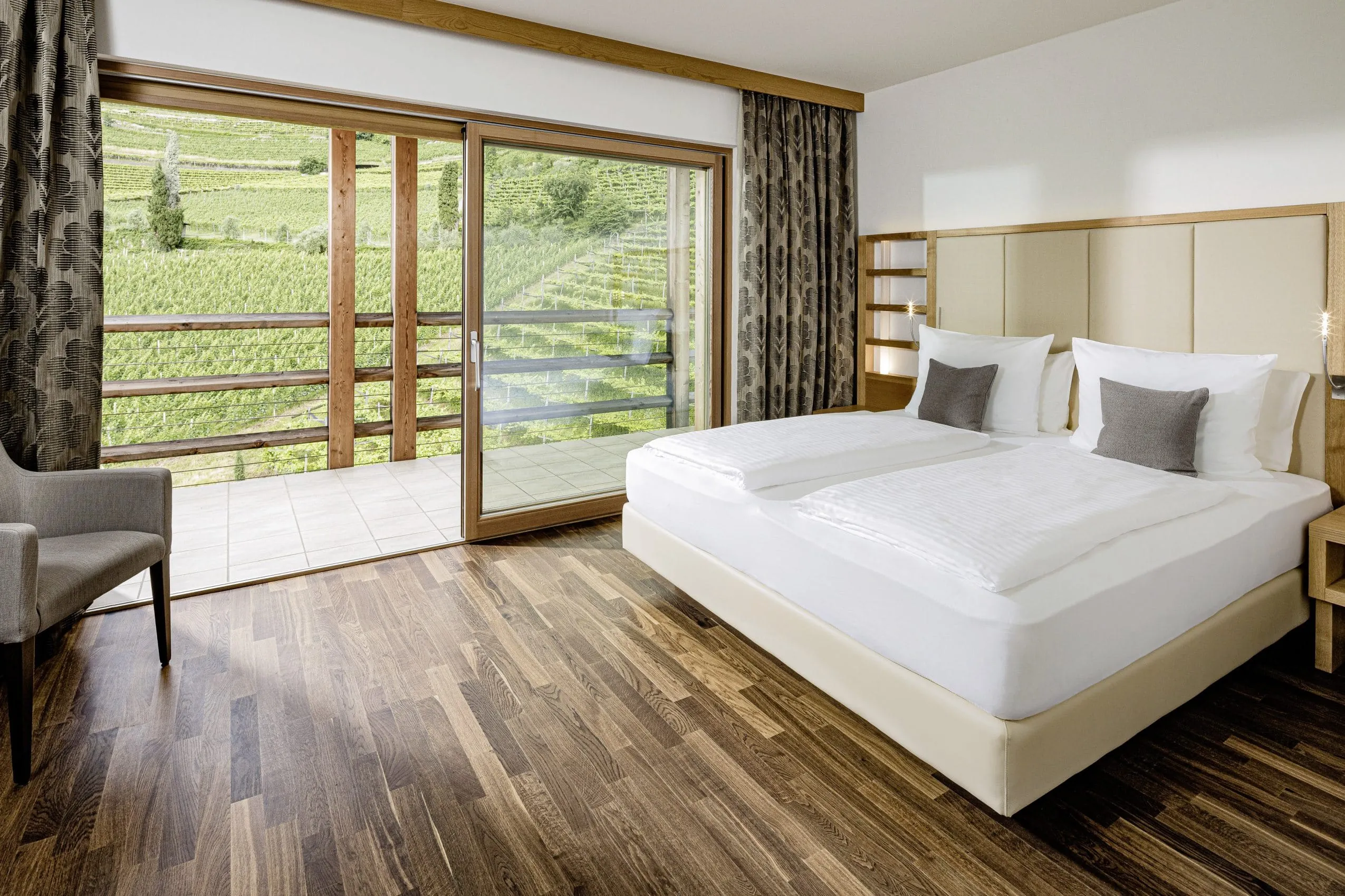 Doppelbett mit Veranda und Weinreben im SEELEITEN Lake Spa Hotel in Kaltern.