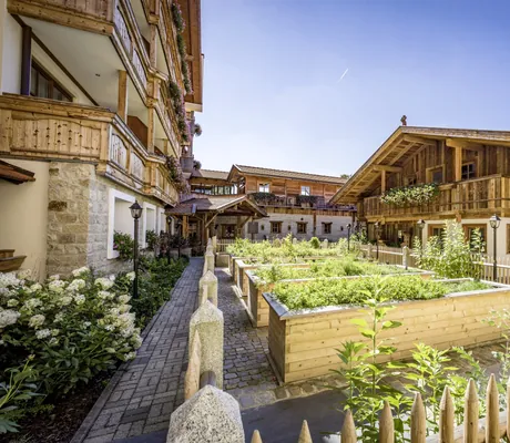 Ein Teil des Innenhofs im Natur- und Wellnesshotel Brunner Hof in Arnschwang mit Hochbeeten aus Holz.