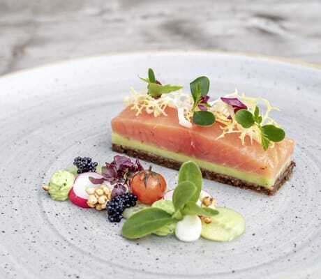 Ein Teller mit Lachs und appetitlich angerichtetem Gemüse aus dem Hotelrestaurant Brunner Hof in Arnschwang.