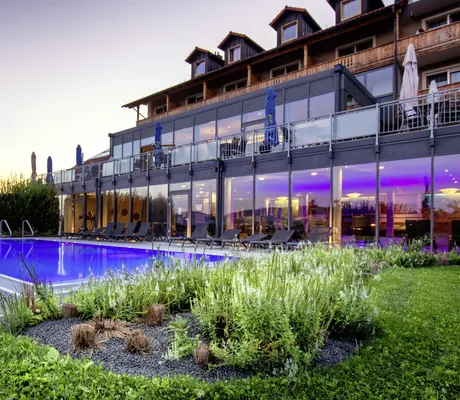 Panorama-Glasfronten der Außenfassade des Landrefugiums Obermüller in Untergriesbach, mit Pool im Vordergrund.