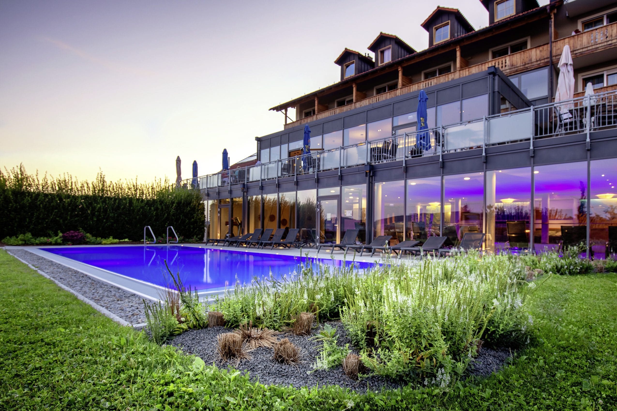 Panorama-Glasfronten der Außenfassade des Landrefugiums Obermüller in Untergriesbach, mit Pool im Vordergrund.