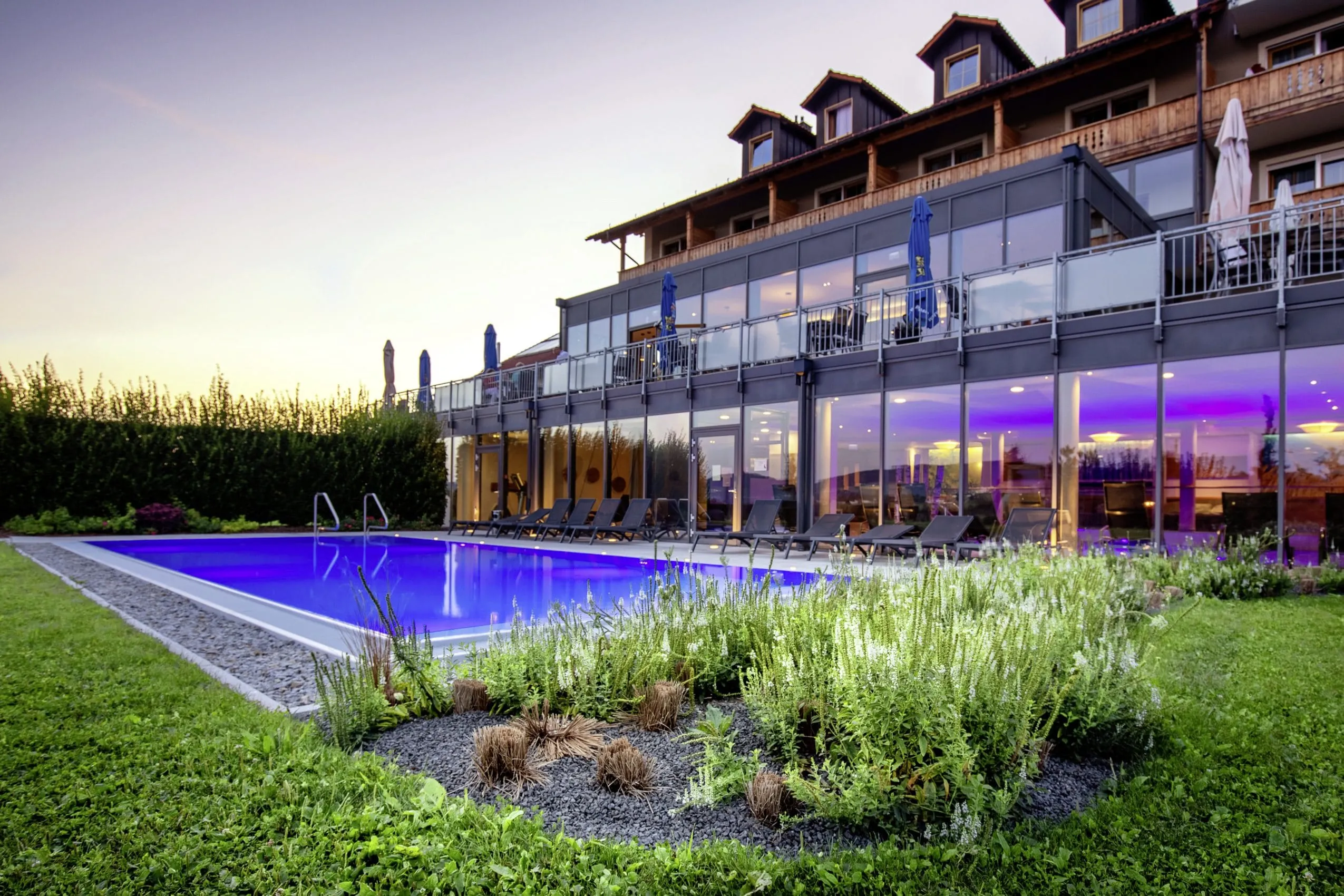 Panorama-Glasfronten der Außenfassade des Landrefugiums Obermüller in Untergriesbach, mit Pool im Vordergrund.