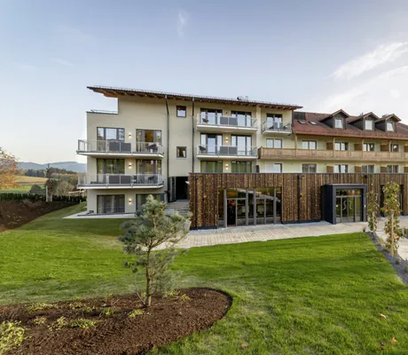 Blick auf die Häuserfassade des Landrefugium Obermüller in Untergriesbach mit grüner Wiese.
