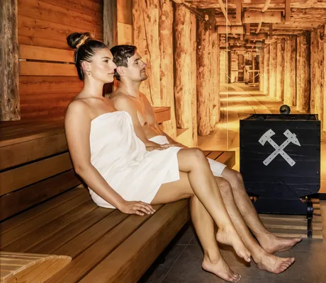 Ein Paar sitzt in der Stollensauna des Landrefugium Obermüller in Untergriesbach.