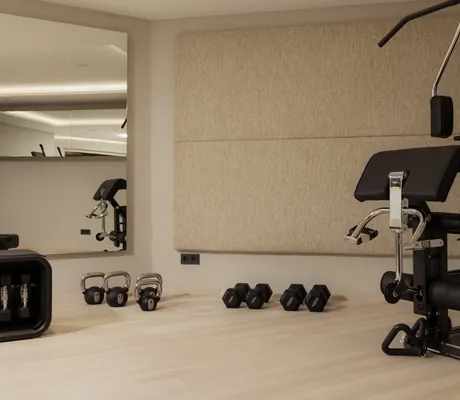 Fitnessgerät und Hanteln im Fitnessraum der Schlossanger Alp mit beiger Stoffwand