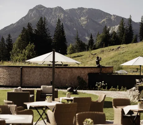 Terrasse mit weißen Sonnenschirmen und Blick auf die Berge in der Schlossanger Alp