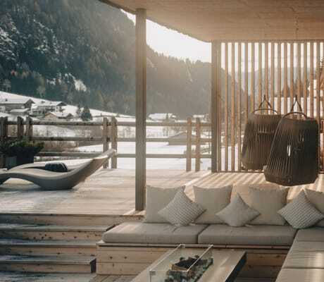 Großer Balkon der Südtirol Chalets Valsegg mit Outdoorsofa und Feuerstelle