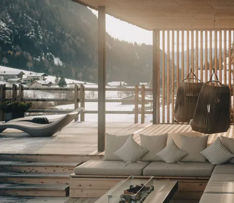 Großer Balkon der Südtirol Chalets Valsegg mit Outdoorsofa und Feuerstelle