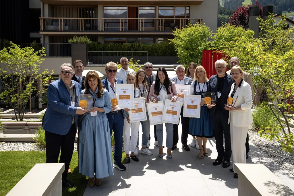 Gruppe von Hoteliers mit Trophäen und Urkunden vor dem Falkensteiner Kronplatz