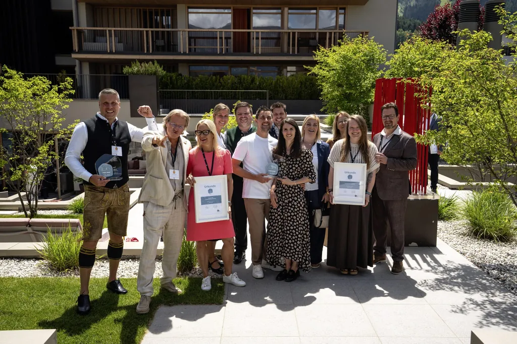 Gruppe von Hoteliers mit Trophäen und Urkunden vor dem Falkensteiner Kronplatz