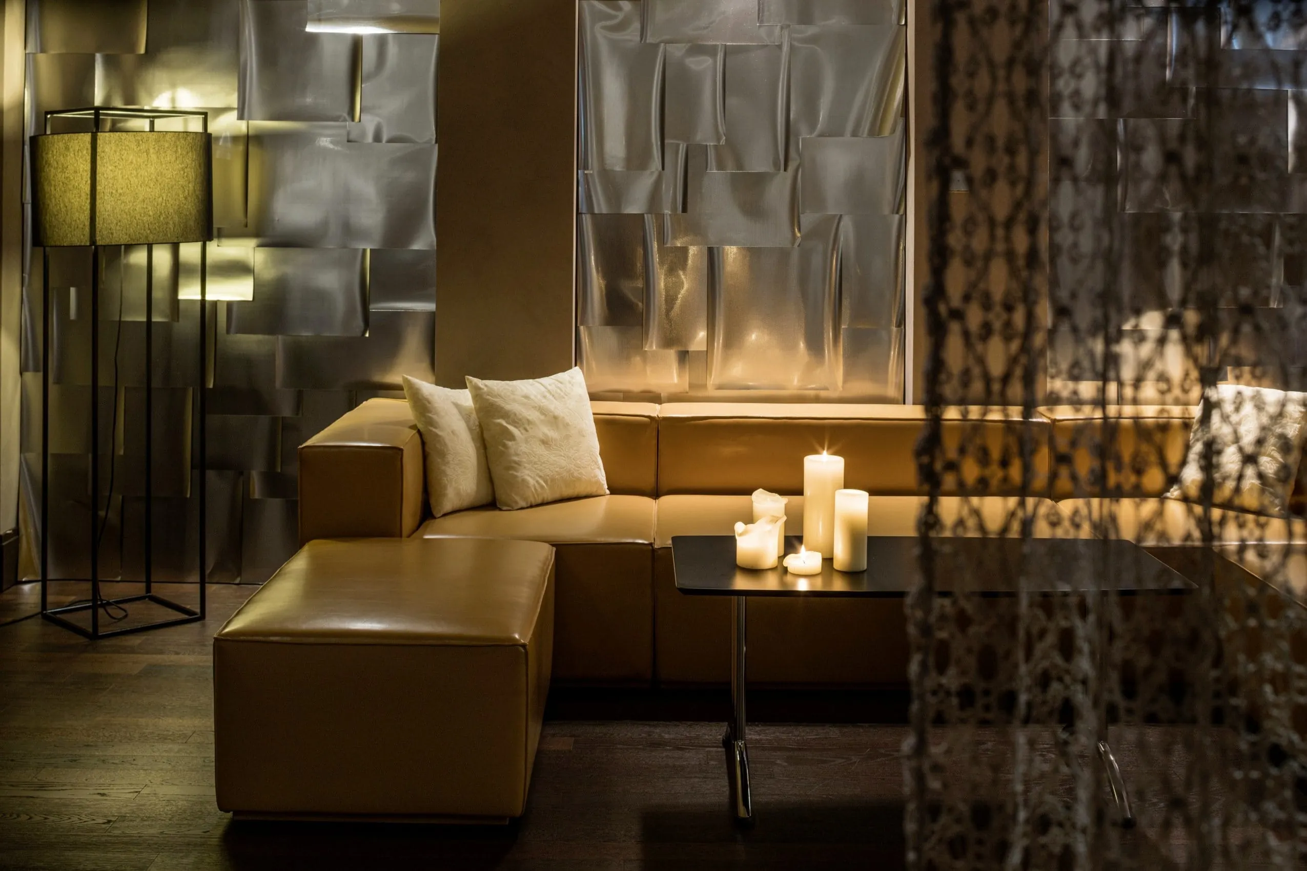 Das Spa im Falkensteiner Schlosshotel Velden mit gelber Ledercouch und Kerzen.